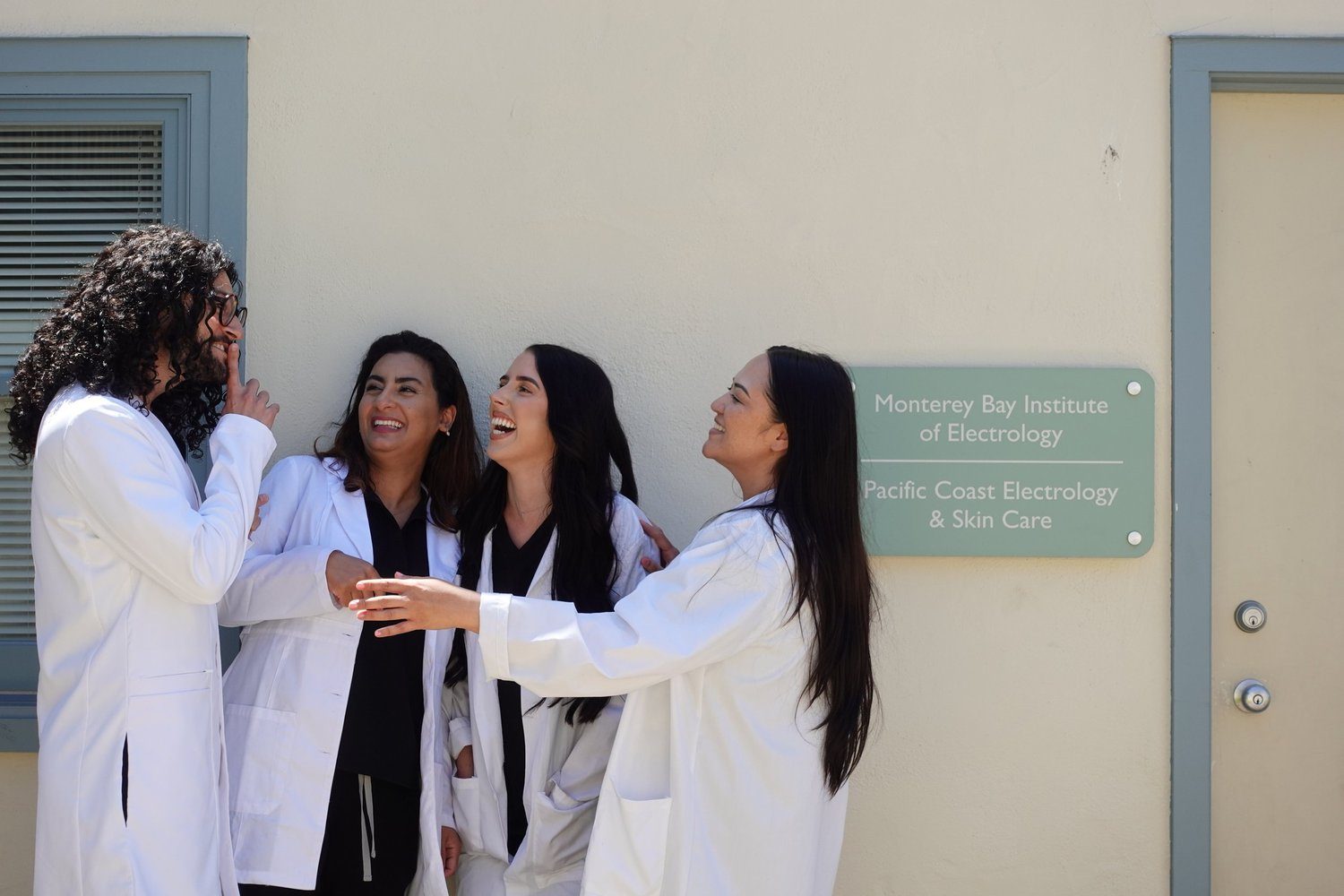 The smoothe electrolysis team laughing together in white coats